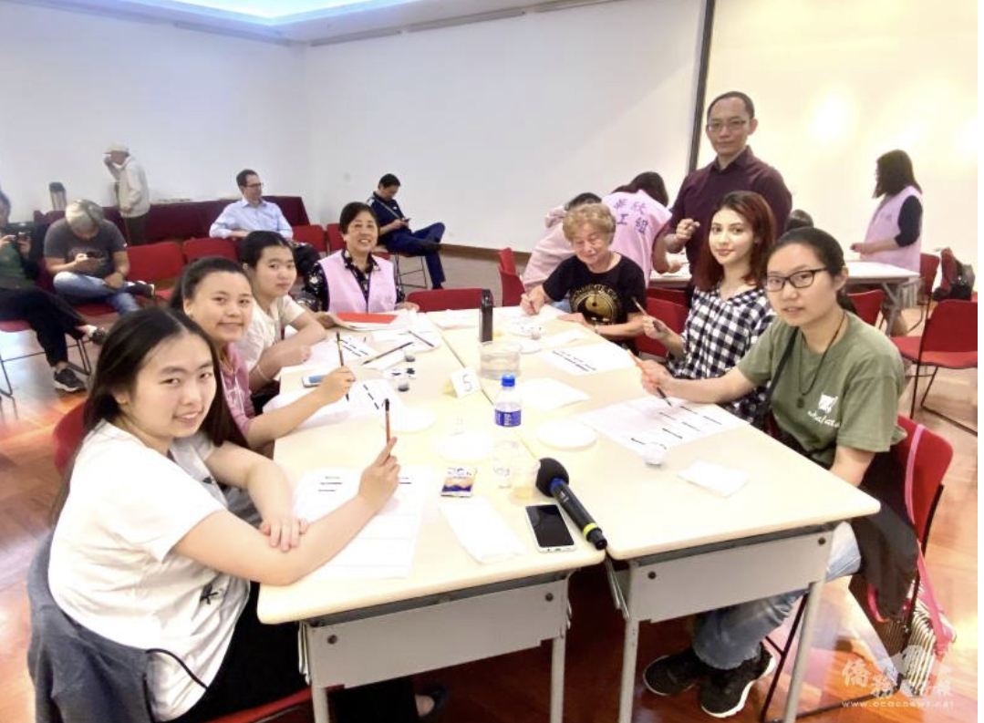 羅明宗（右站者）指導學生如何執筆書寫