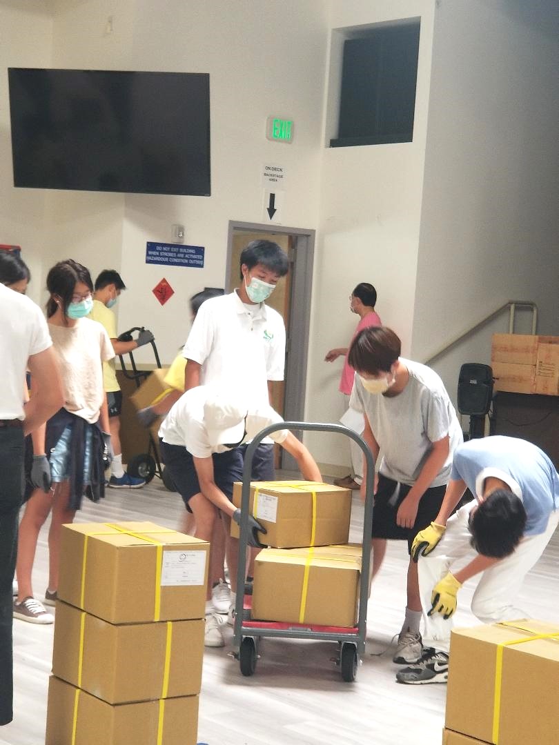 認真負責的青少年志工，沒有怨言一箱接一箱的搬運
