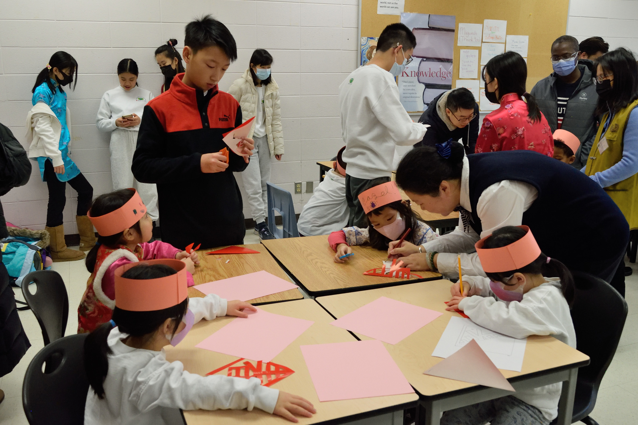 @新年迎春站-----孩子們在張媛媛老師及大哥哥大姊姊和家長們的協助下完成剪春字，迎接新年。