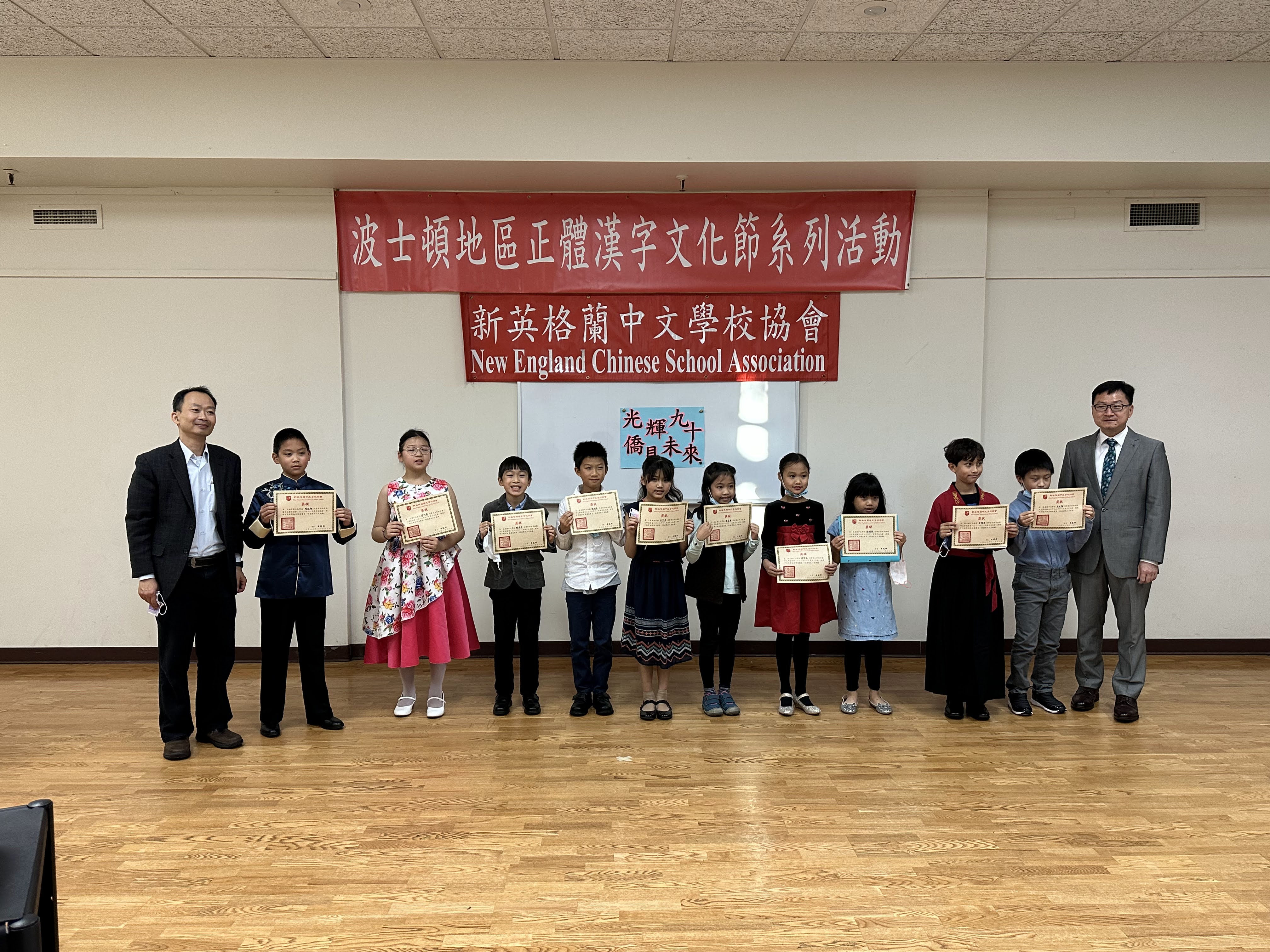 波士頓文教中心潘昭榮主任 (右一)，新英格蘭中文學校協會會長黃冠群 (左一) 及朗誦比賽中年級A組參賽學生合影