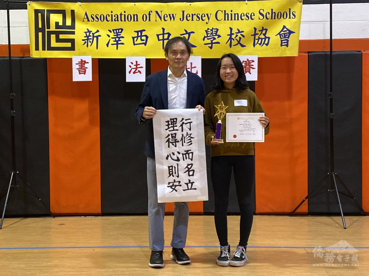 北部慈濟人文學校參賽者方虹心學習寫書法七年，第一次參加書法比賽，一舉獲得第一名，由美東中文學校協會會長戴松昌（左）頒發獎盃