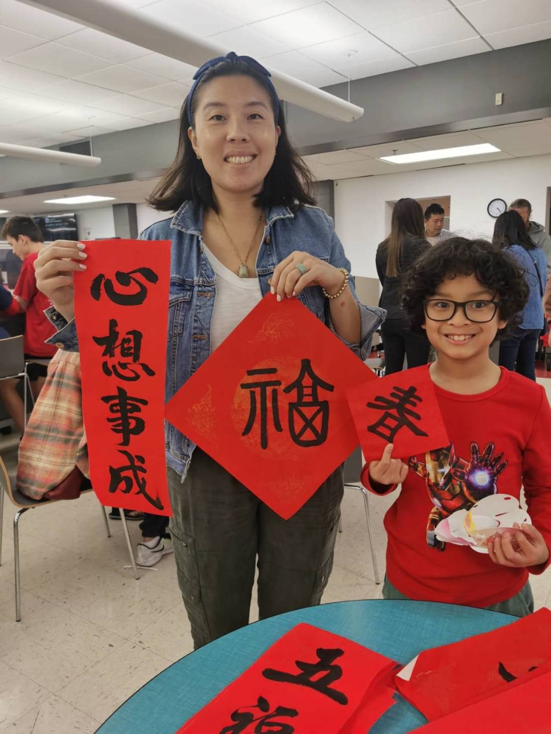 親子一起寫春聯，媽媽說是他第一次跟兒子寫春聯，她非常的感動。